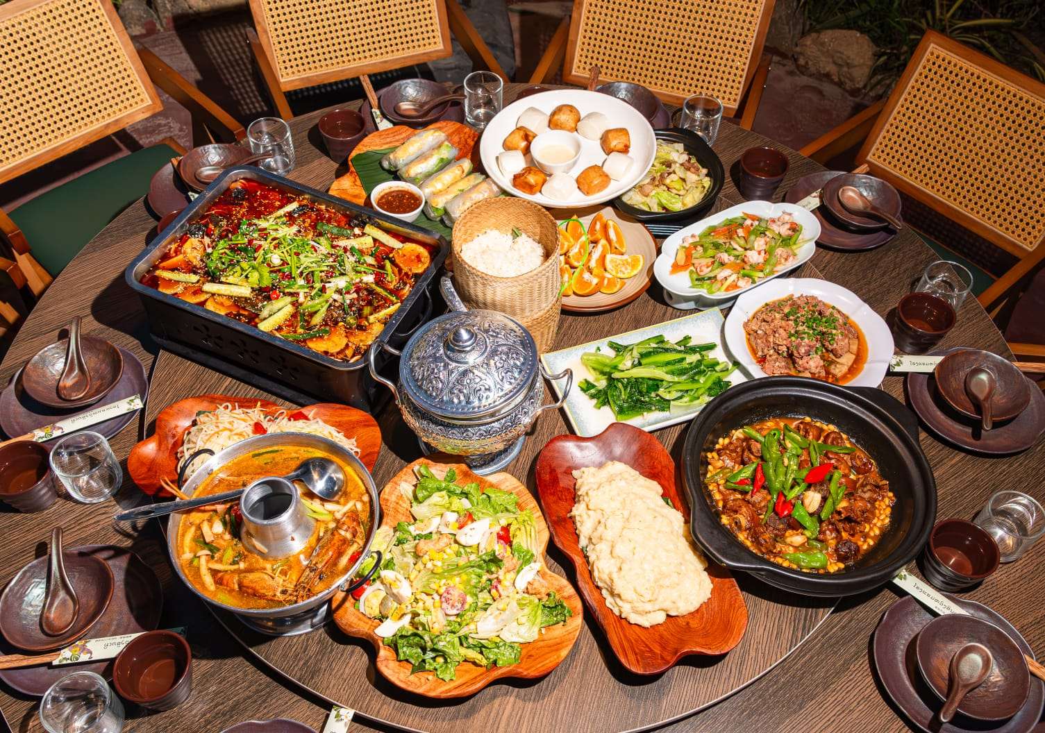 Large table of Lao and Chinese dishes served on site
