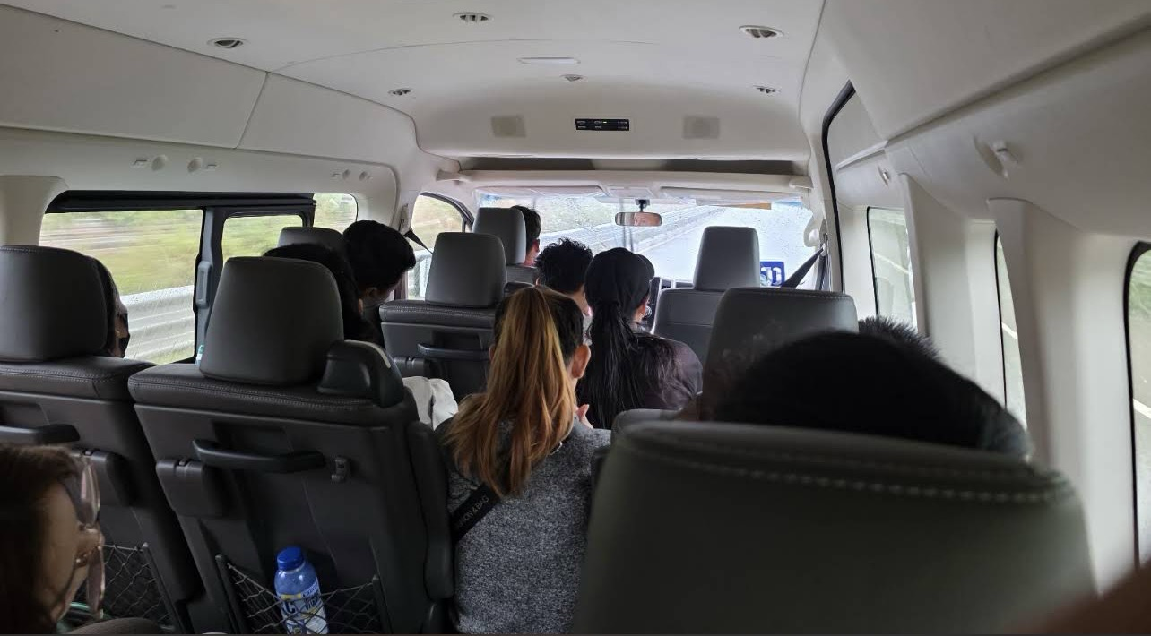 White minivan used for hotel pick-up and drop-off in Vang Vieng