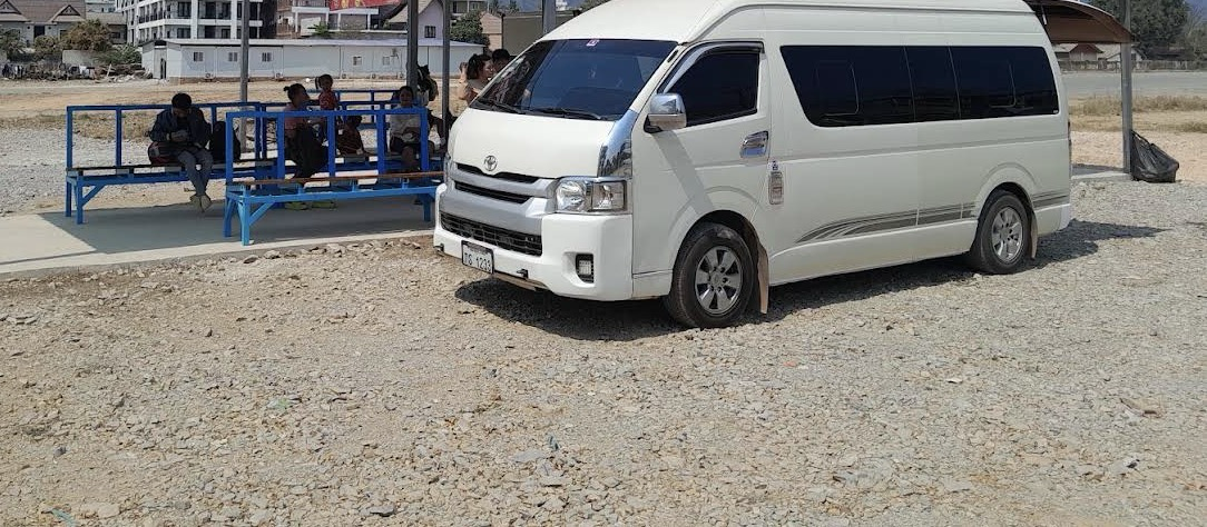 White minivan used for hotel pick-up and drop-off in Vang Vieng