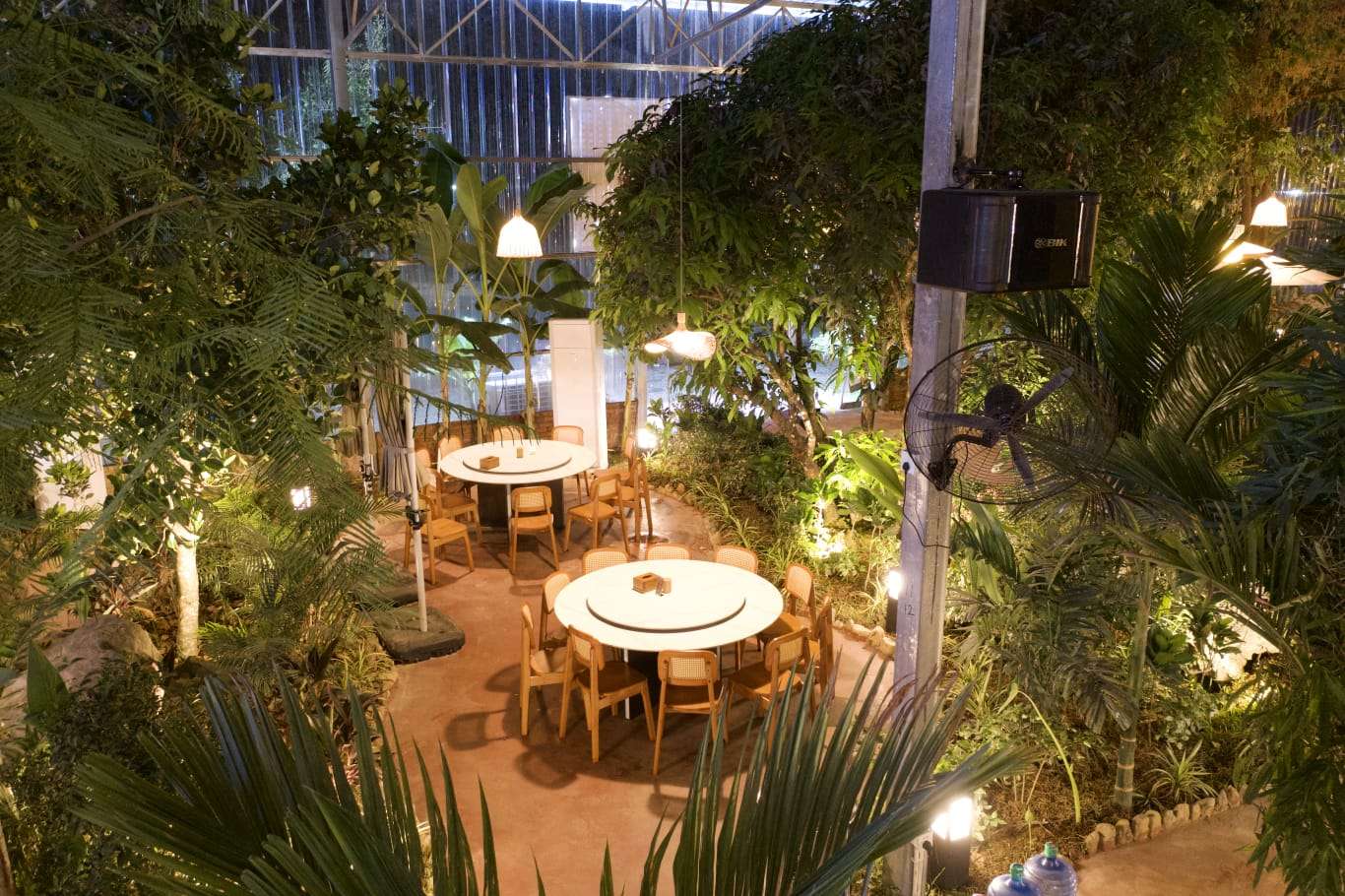 Round tables and wooden chairs among tropical plants