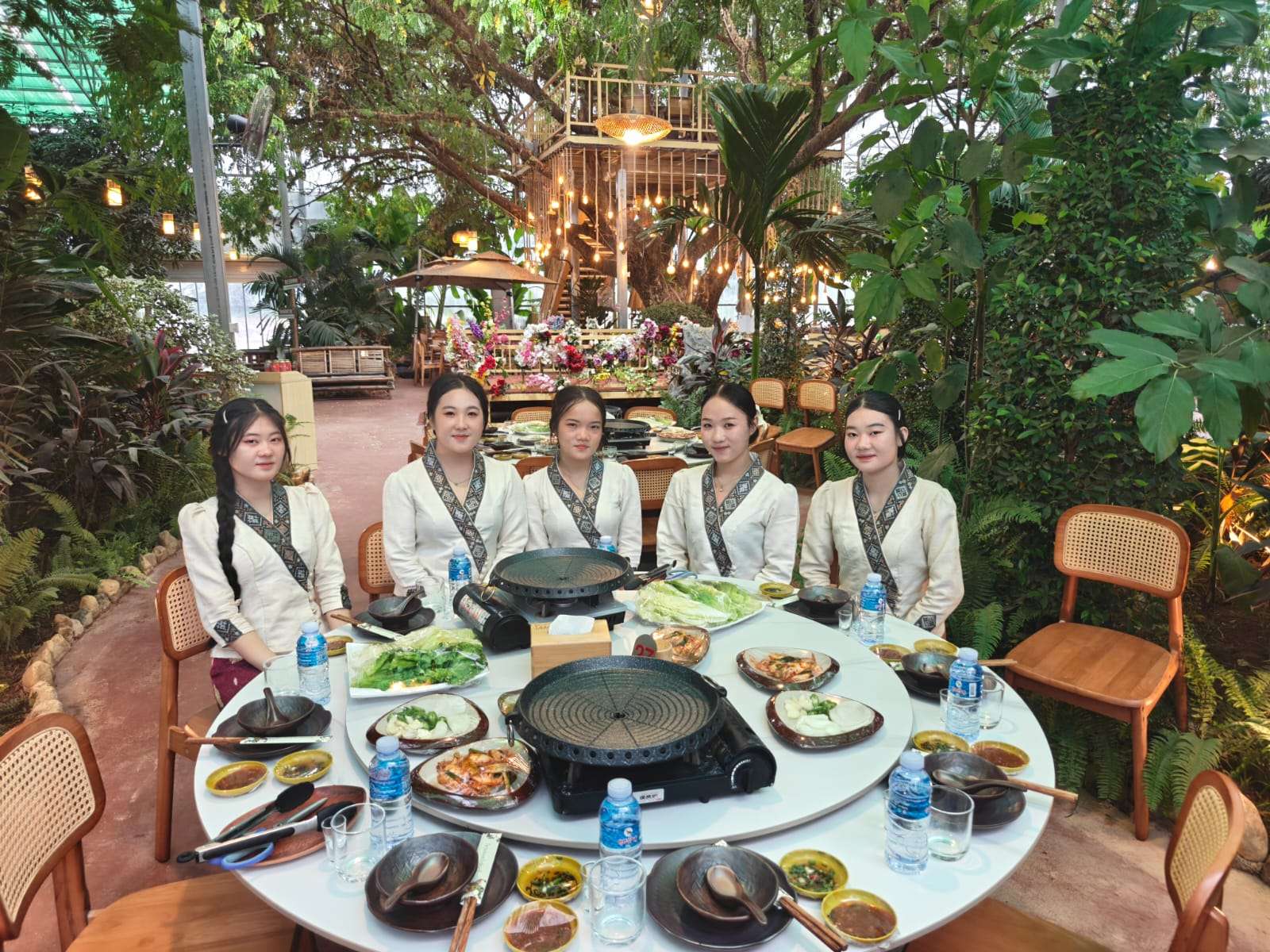 Round dining table with barbecue grills in the green restaurant area