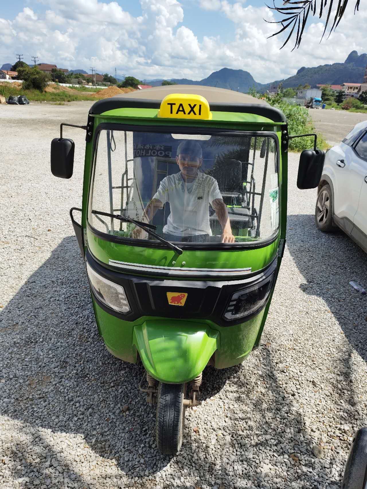 Green tuk-tuk used for pick-up and drop-off at Vang Vieng Elephant Experience